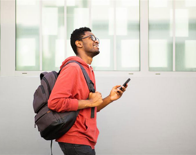 Male student using mobile access on campus