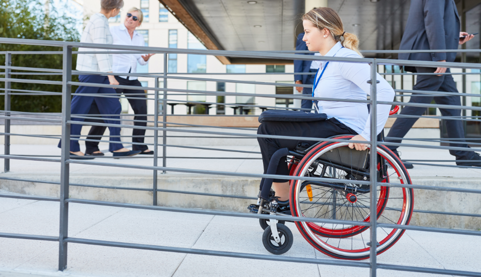 Woman in wheelchair going up ADA compliant ramp