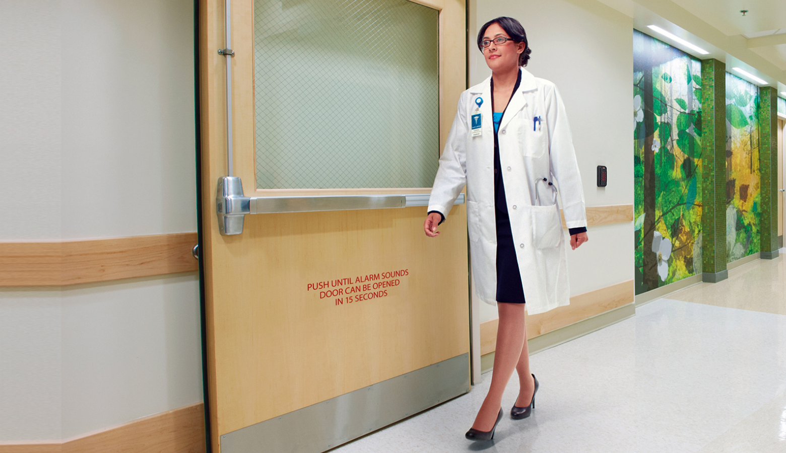 Physician walking through ER door with networked wired door hardware